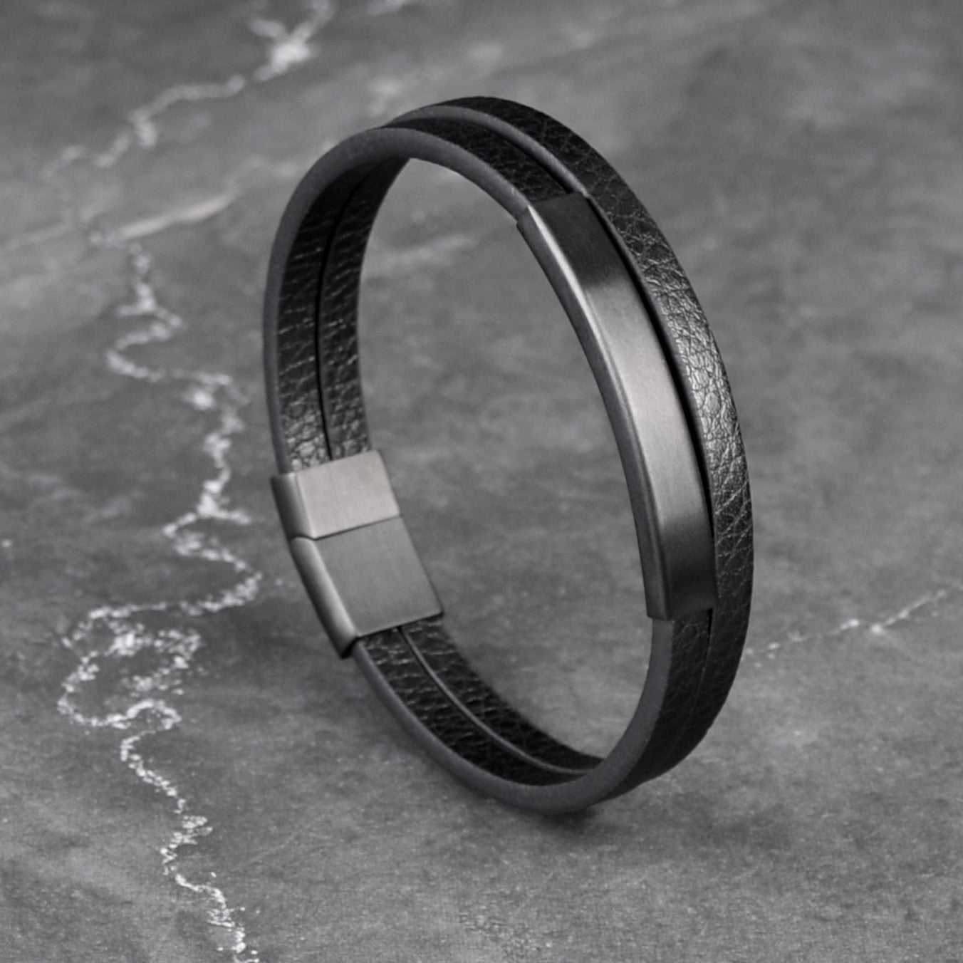 Multi-layer leather bracelet with black matte tube and black 316L stainless steel clasp, angle view