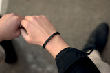 Well-dressed man wears a sleek black leather bracelet from Rianrix Accessories 